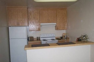 kitchen with brown cabinets, white appliances, breakfast bar